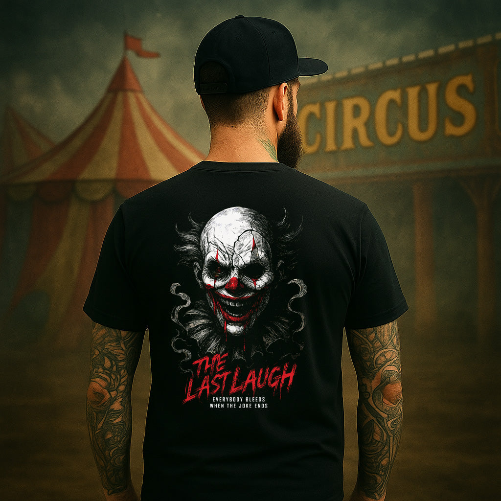 Person wearing a black t-shirt with a clown graphic and text in front of a circus tent.