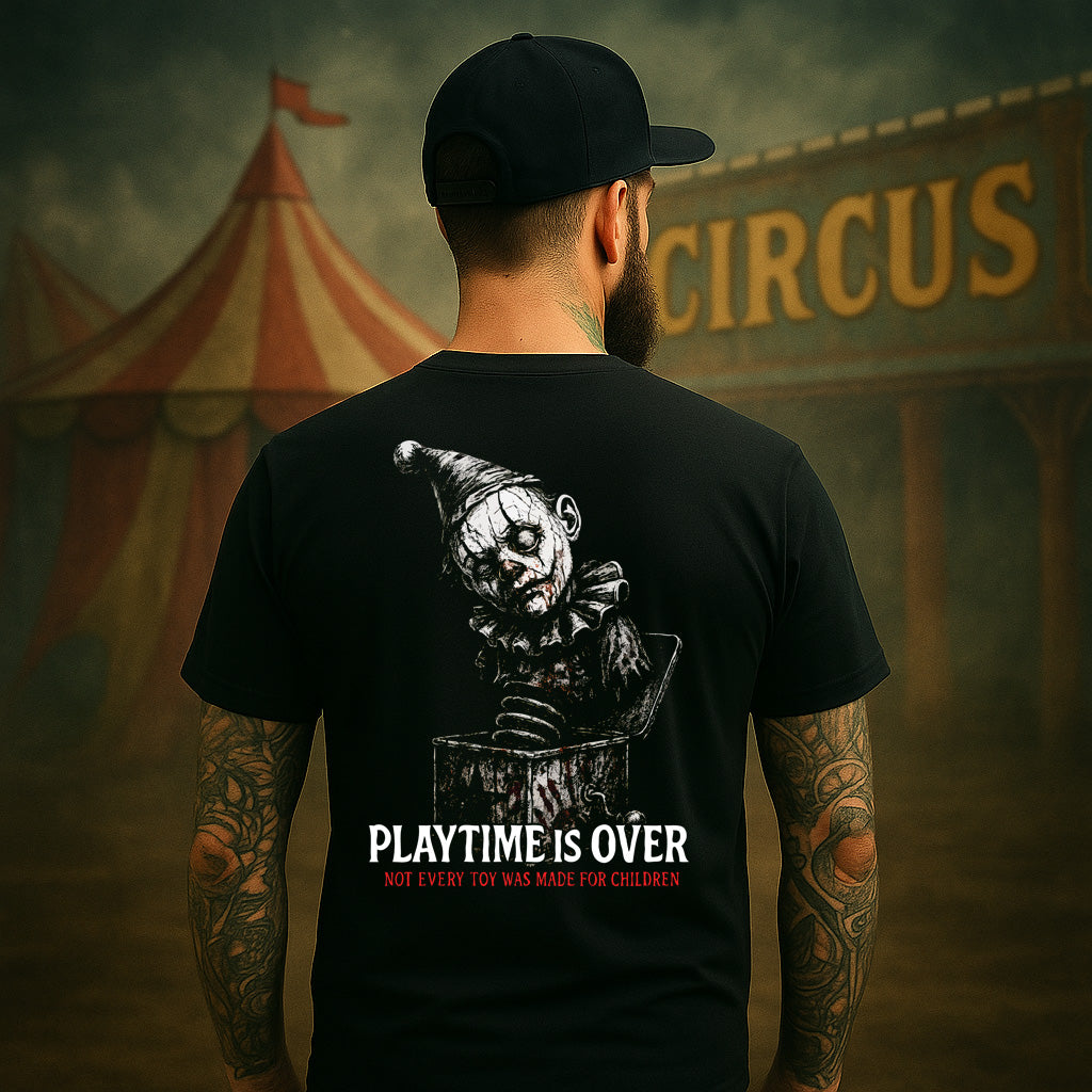 Person wearing a black t-shirt with a graphic design and text, standing in front of a circus tent.