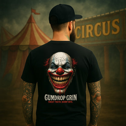 Person wearing a black t-shirt with a clown graphic and 'Gumdrop Grin' text, standing in front of a circus tent.