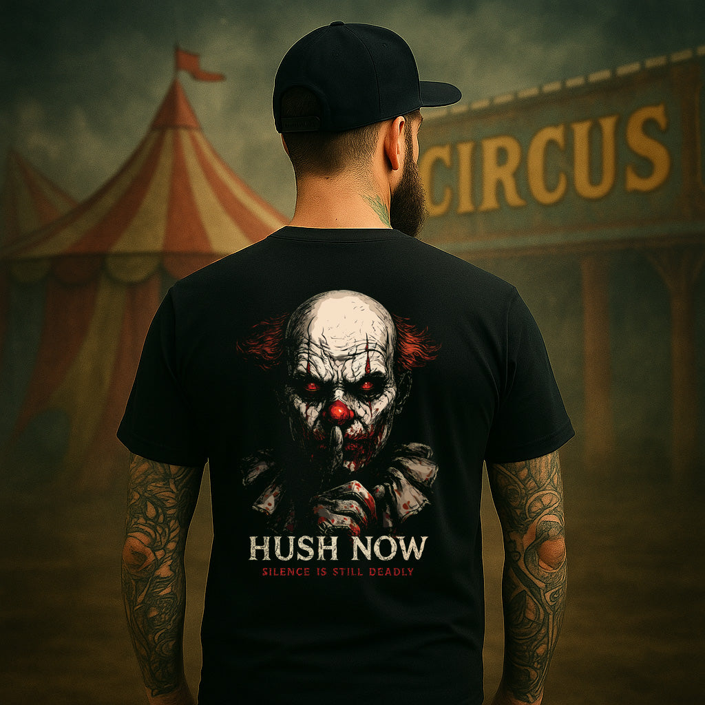Person wearing a black t-shirt with a clown graphic and text, standing in front of a circus tent.