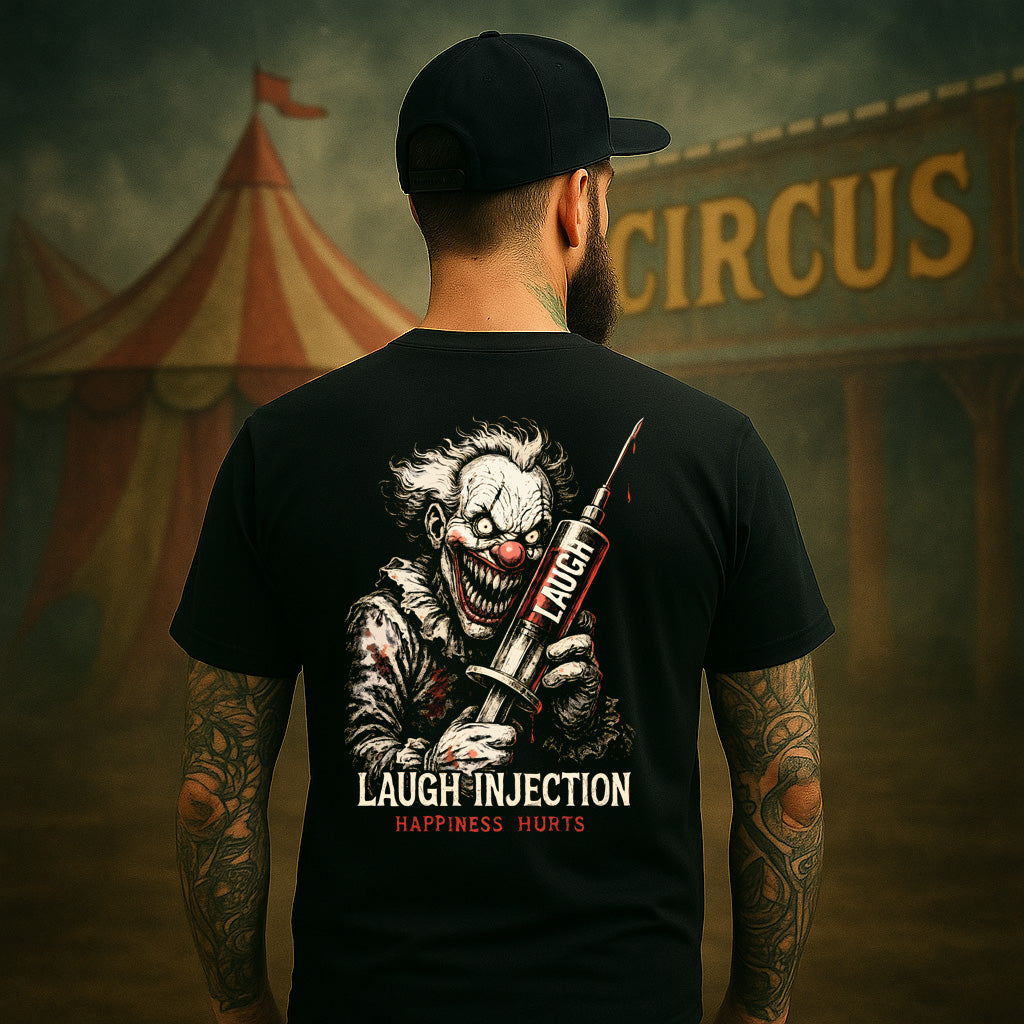 Person wearing a black t-shirt with a clown graphic and text, standing in front of a circus tent.