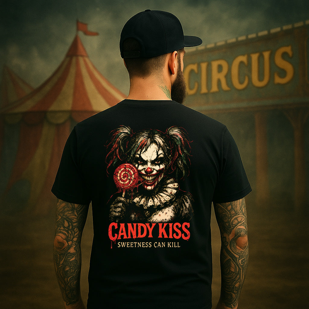 Person wearing a black t-shirt with a clown graphic and text, standing in front of a circus tent.