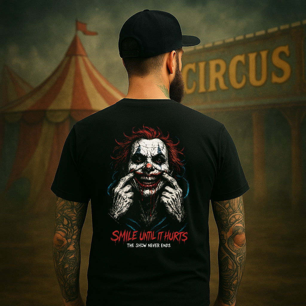 Person wearing a black t-shirt with a clown graphic and text, standing in front of a circus tent.