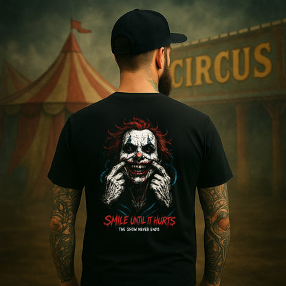 Person wearing a black t-shirt with a clown graphic and text, standing in front of a circus tent.